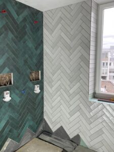 Modernes Badezimmer mit Fischgrät-Fliesen in Düsseldorf – stilvolle Fliesengestaltung von MK Innenausbau