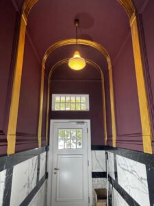 Eleganter Treppenhaus mit Stuck, goldenen Elementen und dunkler Decke – Oberkassel