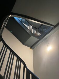 Eleganter Treppenhaus mit Stuck, goldenen Elementen und dunkler Decke – Oberkassel