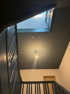 Eleganter Treppenhaus mit Stuck, goldenen Elementen und dunkler Decke – Oberkassel