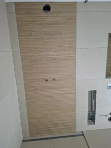 Detail der bodenebenen Dusche mit Holzoptik-Akzentwand im Badezimmer in Düsseldorf – MK Innenausbau