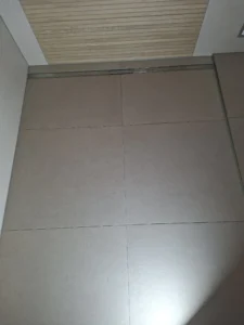 Modernes Badezimmer mit bodenebener Dusche, großformatigen Fliesen und Holzoptik-Akzentwand in Düsseldorf – MK Innenausbau