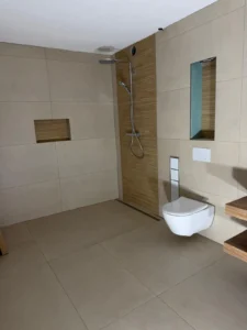 Bodenebene Dusche im modernen Badezimmer mit Holzoptik-Fliesen in Düsseldorf – ausgeführt von MK Innenausbau