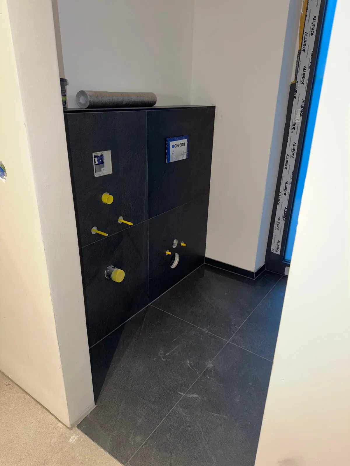 Modernes WC mit schwarzen Fliesen und stilvollem Design